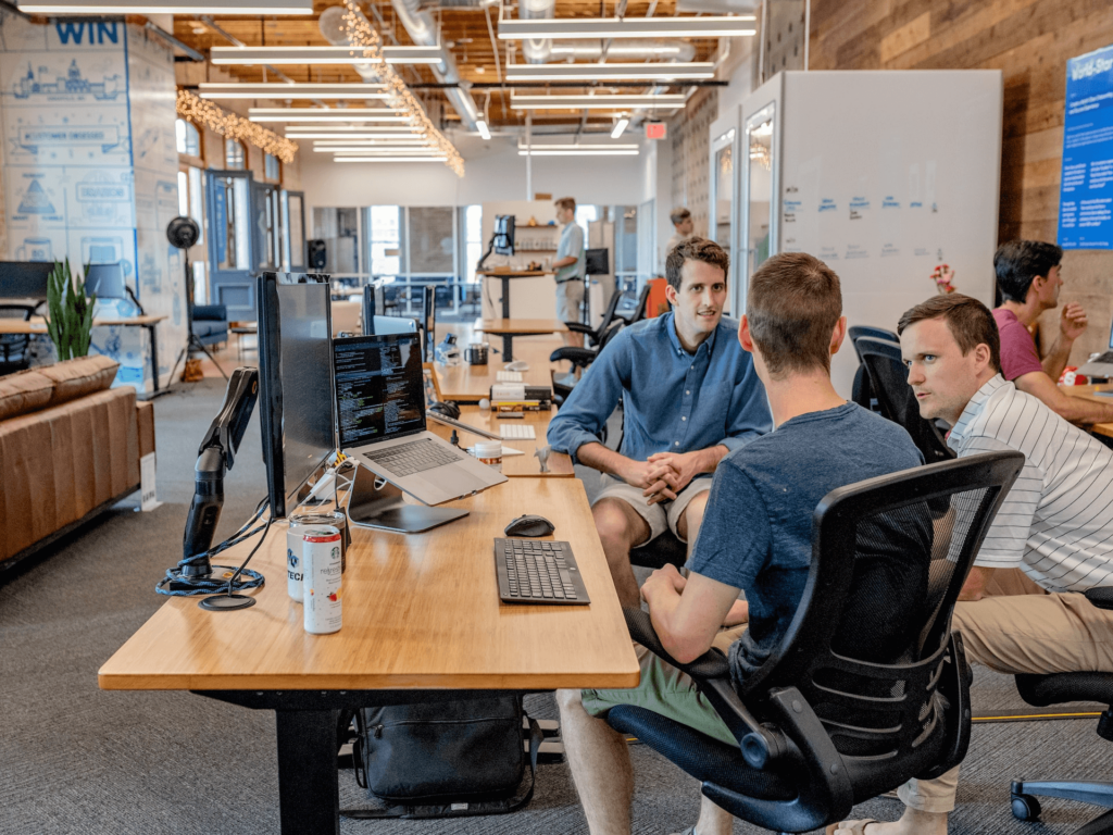 Three men engaged in a productive discussion during an organizational coaching session at a company, emphasizing teamwork and growth